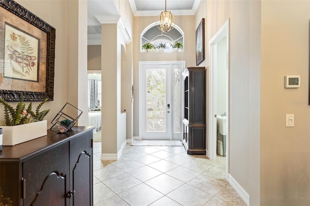 entryway featuring ornamental molding, light tile patterned floors, and an inviting chandelier