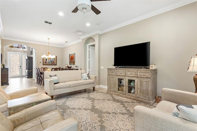 living room featuring ceiling fan with notable chandelier, crown molding, and carpet floors