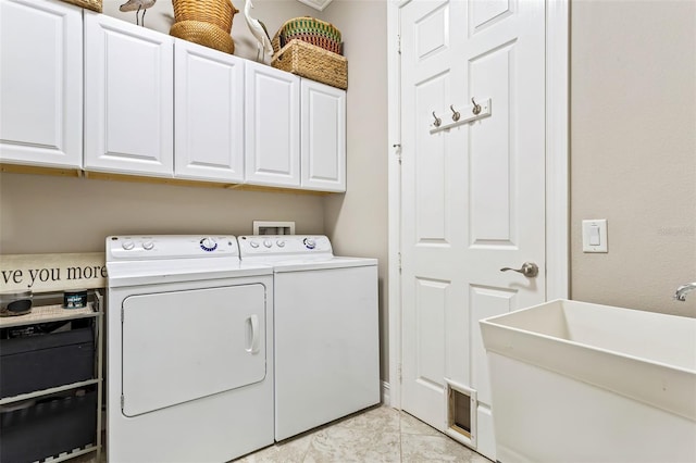 clothes washing area with light tile patterned floors, sink, cabinets, and washing machine and dryer