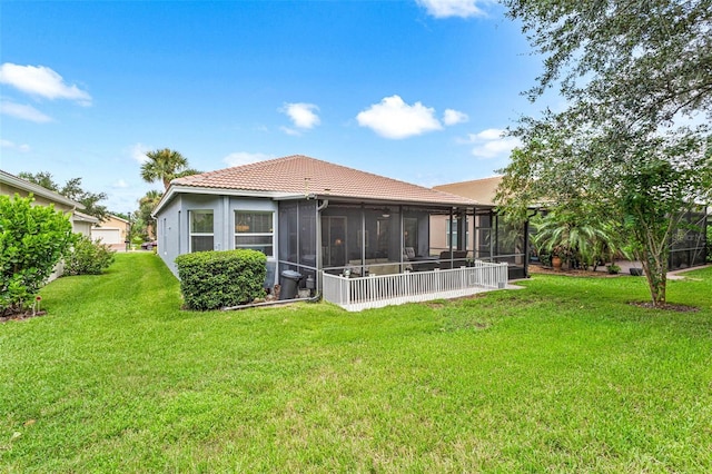 rear view of house with a lawn and a sunroom