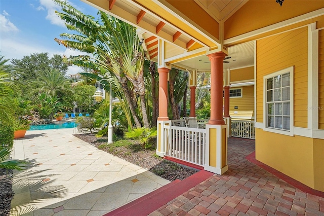 view of patio / terrace with an outdoor pool and covered porch