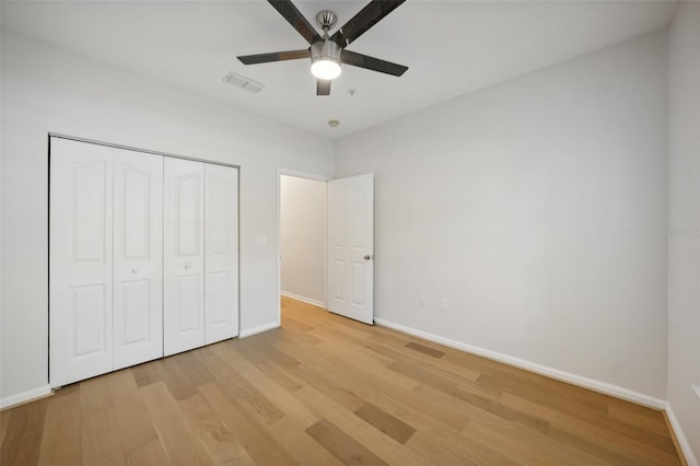 unfurnished bedroom featuring ceiling fan, light hardwood / wood-style floors, and a closet