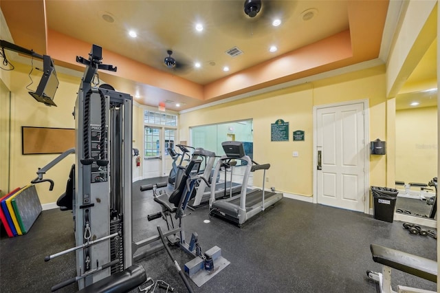 workout area with crown molding and a tray ceiling