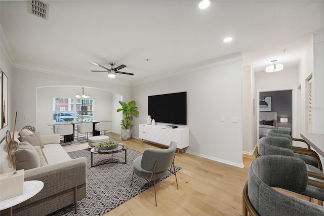 living room featuring ceiling fan with notable chandelier, crown molding, and light hardwood / wood-style floors