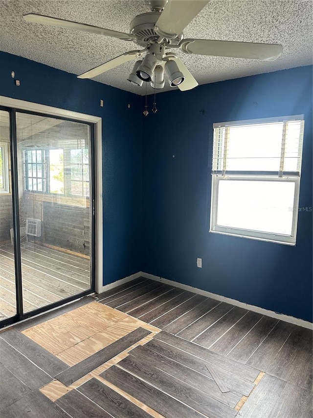 spare room with ceiling fan, a textured ceiling, and dark hardwood / wood-style flooring