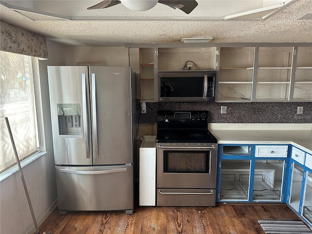 kitchen featuring dark wood-type flooring, ceiling fan, stainless steel appliances, and tasteful backsplash