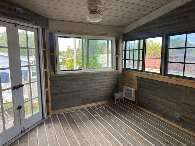 unfurnished sunroom with a wall unit AC, wood ceiling, ceiling fan, and vaulted ceiling