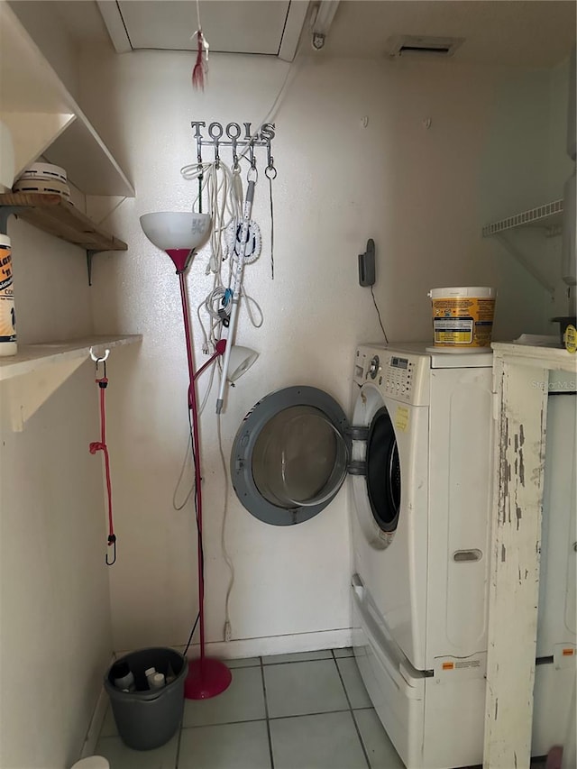 laundry room featuring light tile patterned floors and washing machine and clothes dryer