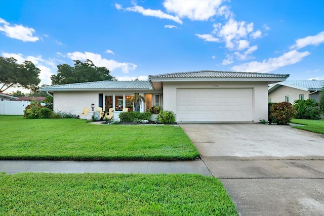 ranch-style home featuring a front yard and a garage