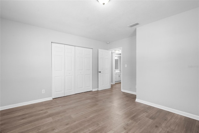 unfurnished bedroom featuring wood-type flooring and a closet