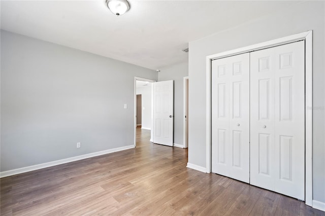 unfurnished bedroom featuring a closet and light hardwood / wood-style floors