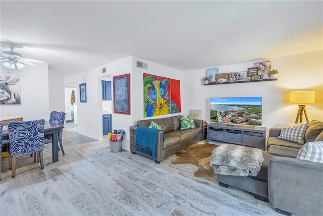 living room featuring ceiling fan and light hardwood / wood-style floors