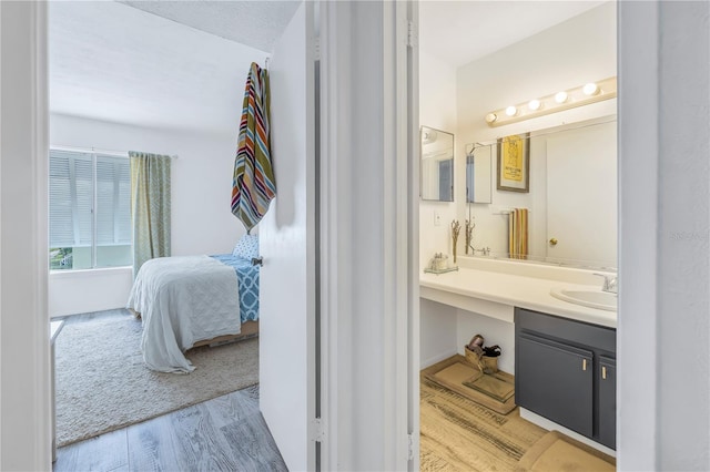 bathroom with vanity, a textured ceiling, and wood-type flooring