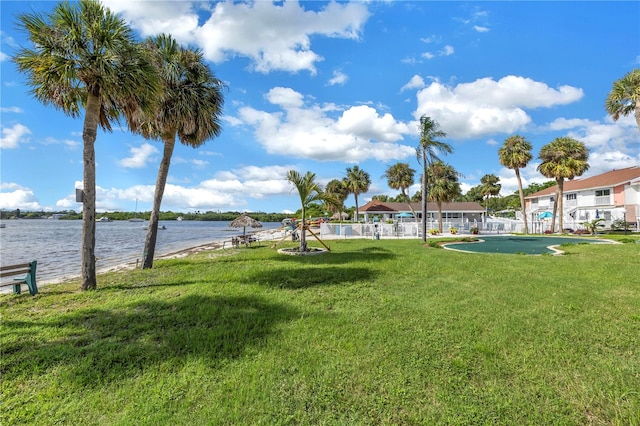 view of property's community with a yard and a water view