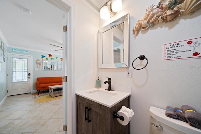 bathroom with vanity, tile patterned flooring, ceiling fan, ornamental molding, and toilet