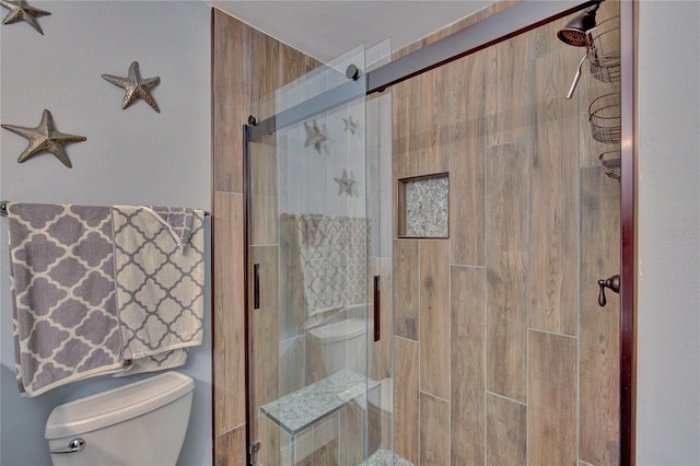 bathroom with toilet and an enclosed shower