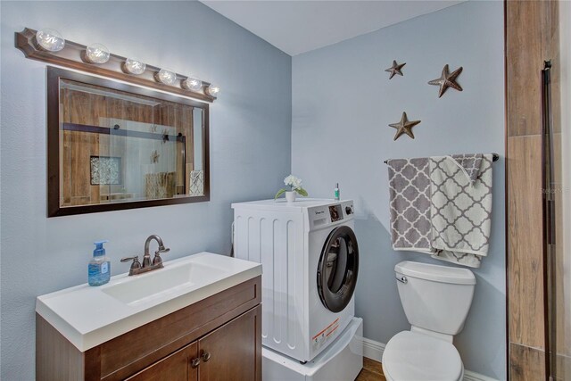 bathroom with washer / dryer, walk in shower, toilet, and vanity