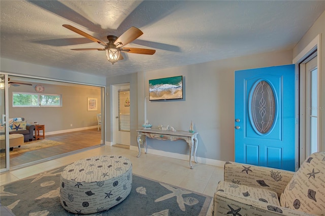 entrance foyer with hardwood / wood-style floors, ceiling fan, and a textured ceiling