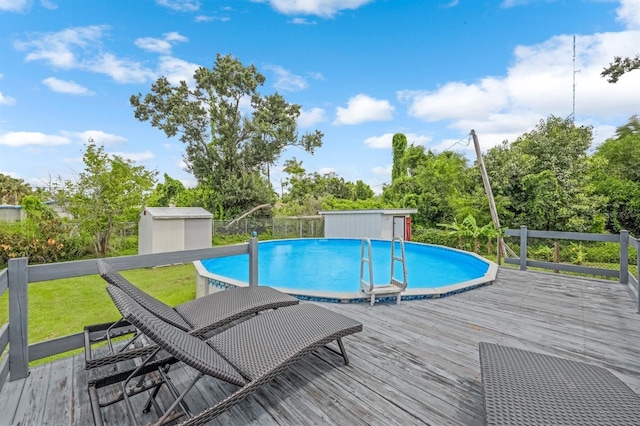 view of swimming pool with a yard, a storage shed, and a deck