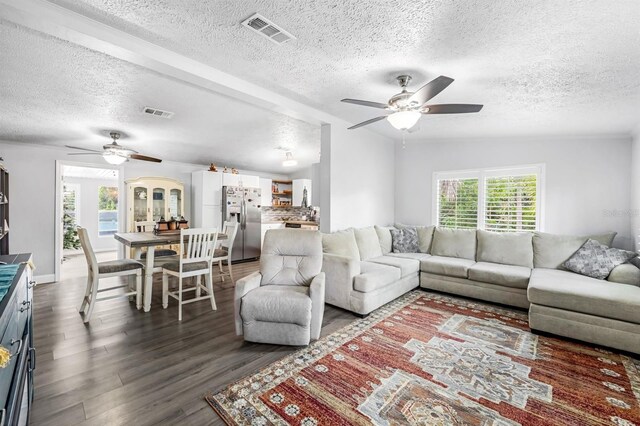 living room featuring ceiling fan, dark hardwood / wood-style floors, vaulted ceiling, and a textured ceiling