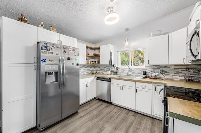 kitchen featuring white cabinets, backsplash, stainless steel appliances, and sink