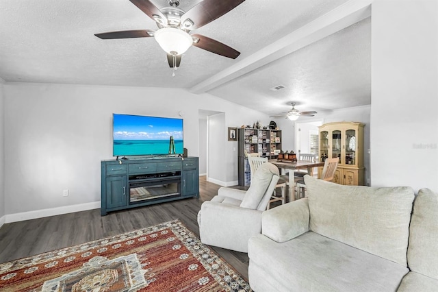 living room with a textured ceiling, dark hardwood / wood-style flooring, ceiling fan, and vaulted ceiling with beams