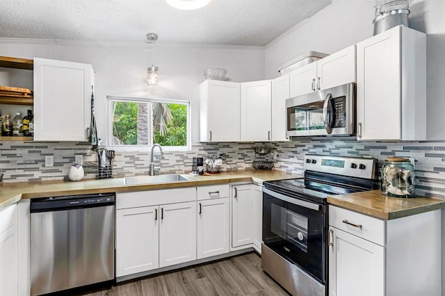 kitchen with a textured ceiling, stainless steel appliances, sink, and white cabinets