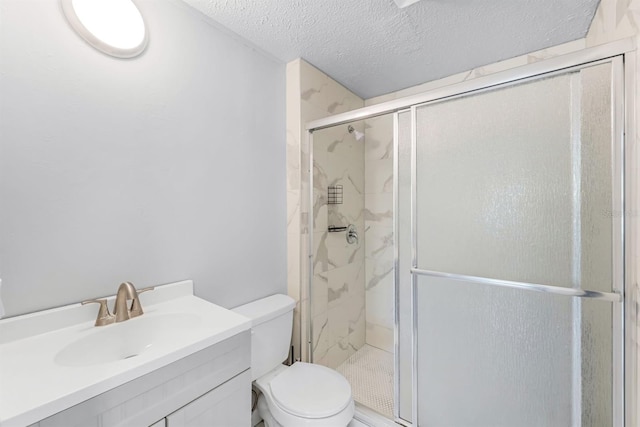 bathroom with a textured ceiling, vanity, toilet, and an enclosed shower