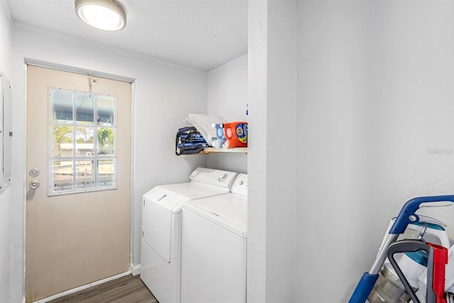 washroom featuring washer and clothes dryer, laundry area, baseboards, and wood finished floors