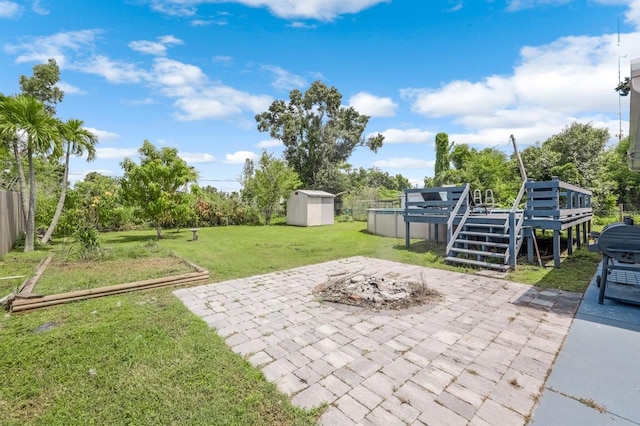 view of patio featuring a shed, an outdoor fire pit, and a pool