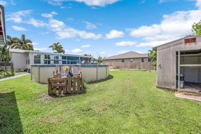 view of yard featuring a fenced in pool and a storage unit