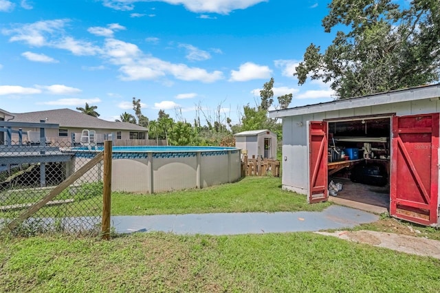 view of yard featuring an outdoor pool, an outdoor structure, a shed, and fence