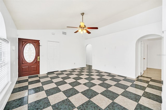 foyer with ceiling fan, a wealth of natural light, and vaulted ceiling