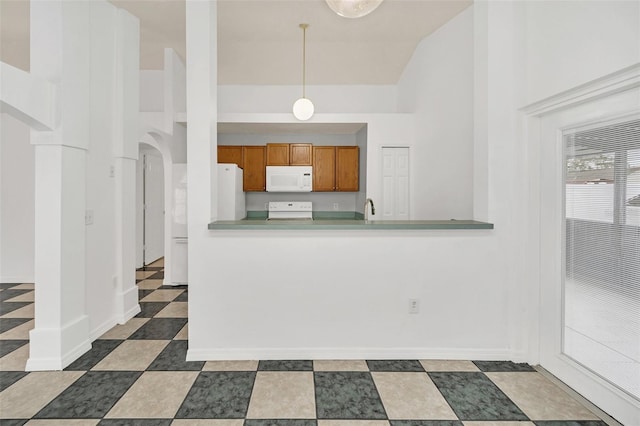 kitchen featuring kitchen peninsula, lofted ceiling, decorative light fixtures, and white appliances