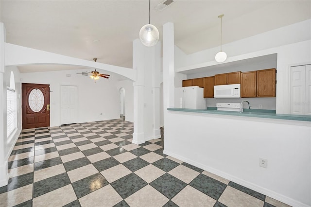 kitchen featuring white appliances, sink, hanging light fixtures, vaulted ceiling, and ceiling fan