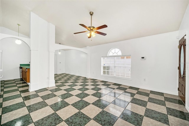 interior space featuring vaulted ceiling, ceiling fan, and ornate columns