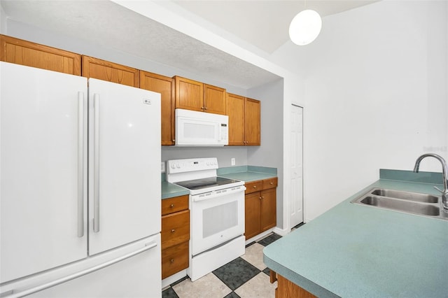 kitchen featuring decorative light fixtures, white appliances, and sink