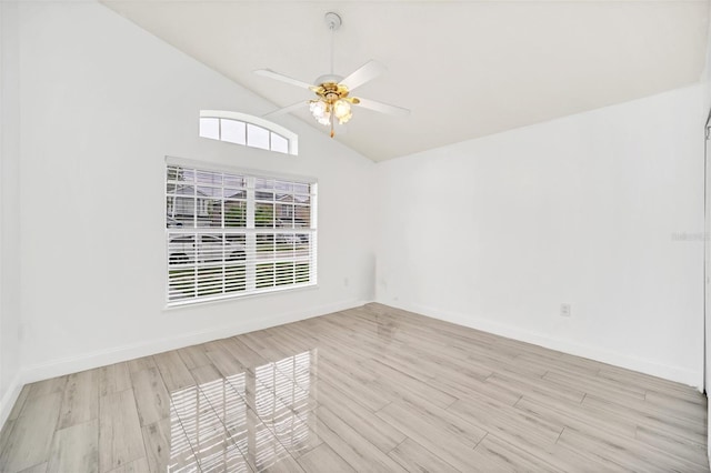 empty room with high vaulted ceiling, light hardwood / wood-style flooring, and ceiling fan