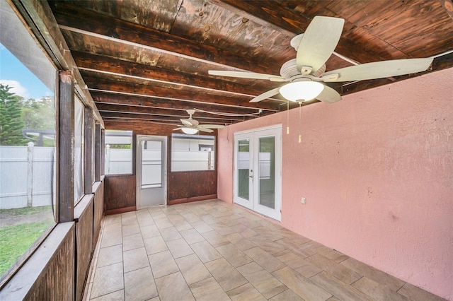 unfurnished sunroom with ceiling fan and french doors