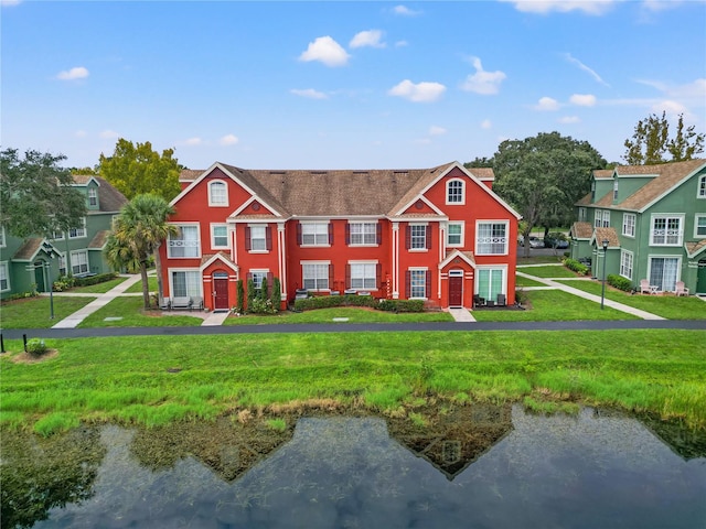 view of front of home featuring a water view and a front lawn