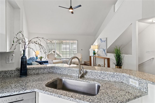 kitchen with vaulted ceiling, sink, white cabinets, dishwashing machine, and ceiling fan