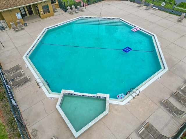 view of swimming pool featuring a hot tub