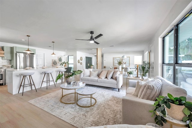 living room with ceiling fan and light hardwood / wood-style floors