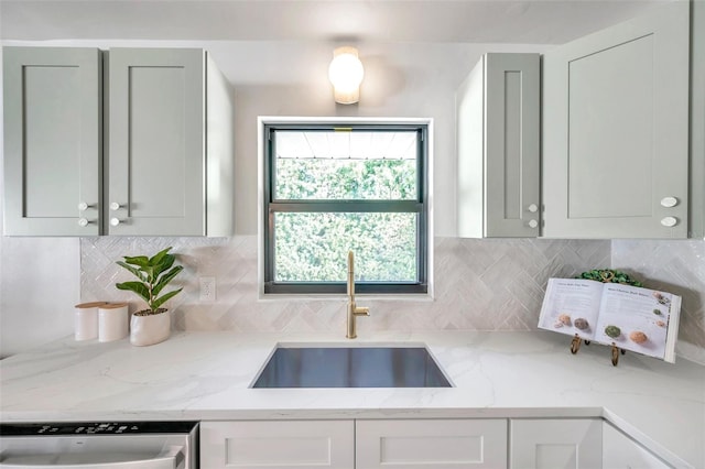 kitchen featuring gray cabinets, sink, light stone countertops, decorative backsplash, and stainless steel dishwasher