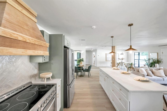 kitchen with tasteful backsplash, light hardwood / wood-style flooring, a kitchen island, appliances with stainless steel finishes, and white cabinets