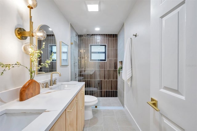 bathroom featuring tiled shower, vanity, toilet, and tile patterned floors