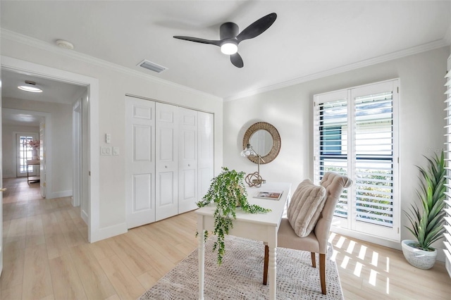 home office featuring light wood-type flooring, ornamental molding, and ceiling fan