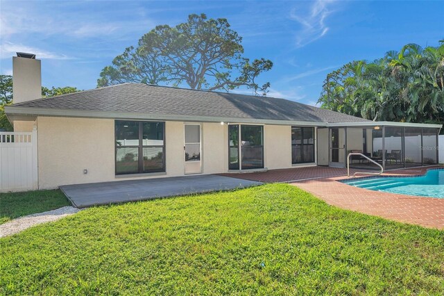 back of property with a lawn and a patio