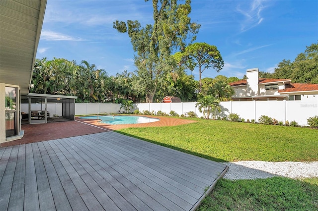 wooden terrace featuring a lawn and a fenced in pool