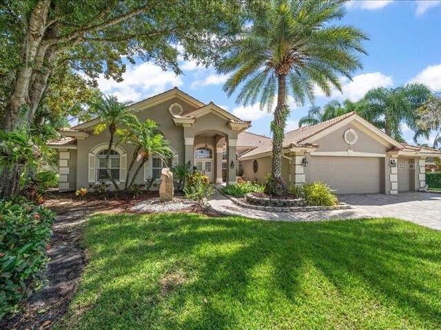 mediterranean / spanish house with a garage and a front yard